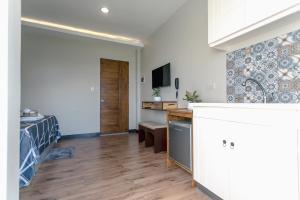a kitchen and living room with a bed and a desk at Midway Stay Apartments Dumaguete in Dumaguete