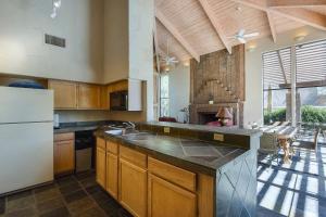 a kitchen with wooden cabinets and a white refrigerator at Canyon Oasis- Canyon View #3214 in Tucson