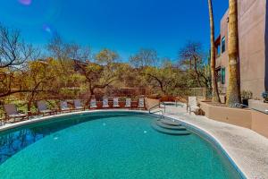 a large swimming pool with chairs and a building at Canyon Oasis- Canyon View #3214 in Tucson