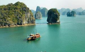 a boat in the water next to a group of islands at Cat Ba Victory Hostel in Cat Ba