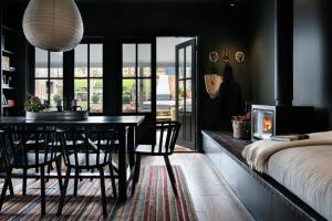 a dining room with a table and a fireplace at Hambleden in Daylesford