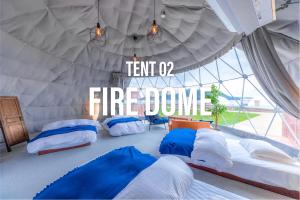 a room with three beds in a tent with a sign at GLAMPDOME SETOUCHI-SHIMANAMI in Onomichi