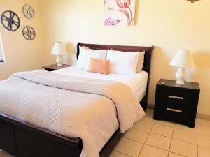 een slaapkamer met een groot bed met 2 nachtkastjes bij White Sands Retreat in Alamogordo