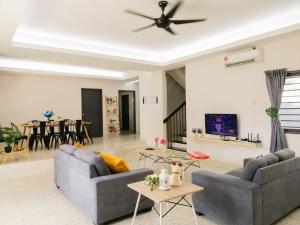 sala de estar con 2 sofás y ventilador de techo en The 29 Bungalow Setapak KL by Manhattan Group, en Kuala Lumpur