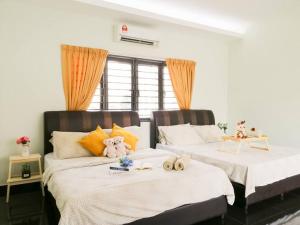 Dos camas con animales de peluche en un dormitorio en The 29 Bungalow Setapak KL by Manhattan Group, en Kuala Lumpur