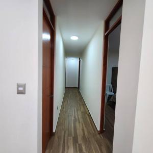 a hallway with a door and a wooden floor at La casa de Teo in Ica