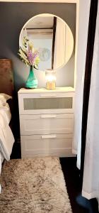 a vase of flowers on a dresser with a mirror at Lakefront living Downtown Toronto - Free Parking, Gym, Indoor Pool in Toronto +4 photos