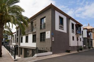 un edificio con una palma di fronte di Apartamentos Las Mozas a Valle Gran Rey