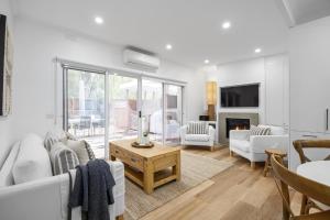 a living room with white furniture and a fireplace at Capella Villa No. 4 - stunning luxury decor inside and out in Blairgowrie