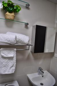 a bathroom with a sink and a mirror and towels at Casa De Camelina in Manila