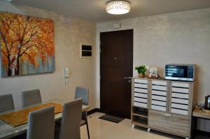 a dining room with a table and a painting on the wall at Casa De Camelina in Manila