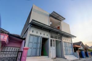 a building with blue doors and windows on a street at SPOT ON 92828 Galih Kost 1 Syariah in Grobogan