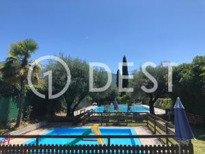 a swimming pool with a sign that reads pueblos at 1Dest - Waterfall & Pool with Garden in Riva del Garda