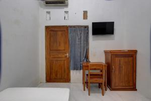 a bedroom with a bed and a desk and a tv at SPOT ON 92828 Galih Kost 1 Syariah in Grobogan