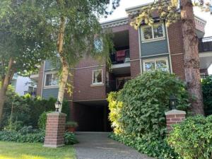 a red brick house with a garage and trees at Kitsilano Beach Executive Condo in Vancouver
