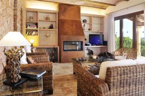 a living room with wicker furniture and a fireplace at s'Albercoquer in Portocolom