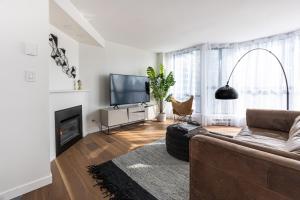 un soggiorno con divano e camino di Amazing Location - 2BDRM/2BATH - right on Robson a Vancouver