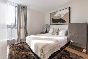 una camera da letto bianca con un letto e una finestra di Amazing Location - 2BDRM/2BATH - right on Robson a Vancouver