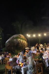 un groupe de personnes assises à table la nuit dans l'établissement Natuna Dive Resort, à Ranai