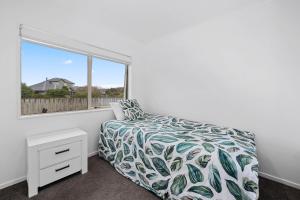 a white bedroom with a bed and a window at Lakeside Haven - Taupo Holiday Home in Taupo