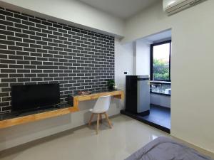 a living room with a tv and a brick wall at Irich Residence สาขา สำโรงใต้ in Samut Prakan