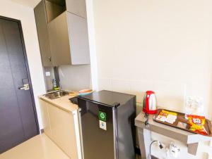 een kleine keuken met een koelkast en een wastafel bij Lovina 8-25 @Citra Plaza Nagoya in Nagoya