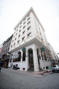 a white building on the corner of a street at Hotel Centrum Istanbul in Istanbul