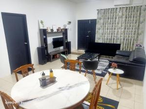 a living room with a table and chairs and a couch at Homestay Izzauni in Kuantan