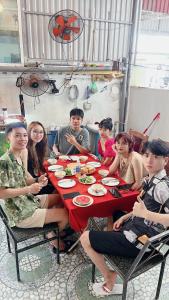 un grupo de personas sentadas alrededor de una mesa comiendo en Cat Ba Mystery Homestay en Cat Ba