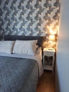 a bedroom with a bed and a lamp on a side table at Centrum Bridge Apartment in Pärnu