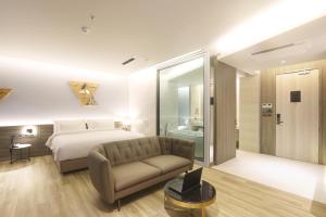 a hotel room with a bed and a couch at The Signature Hotel Airport in Hat Yai