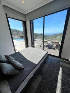 Schlafzimmer mit einem Bett und großen Glasfenstern in der Unterkunft villa vue mer « golf St Tropez » les issambres in Les Issambres + 55 Fotos