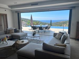 ein Wohnzimmer mit einem Sofa und einem Tisch mit Aussicht in der Unterkunft villa vue mer « golf St Tropez » les issambres in Les Issambres