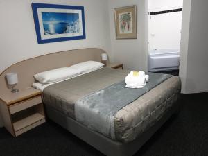 um quarto com uma cama com um bolo em Forstay Motel em Forster