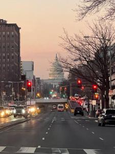 una calle de la ciudad con coches parados en los semáforos rojos en Cherry Blossom Townhouse, Easy DC Access en Washington