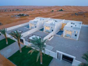 an aerial view of a white house with palm trees at REMAL INN in Bidiyah