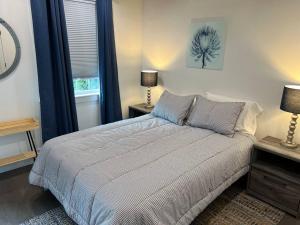 a bedroom with a bed and two lamps and a window at Cherry Blossom Townhouse, Easy DC Access in Washington, D.C.