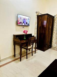 una stanza con scrivania e sedia con vaso di fiori di *Serene* A Luxurious Stay a Jodhpur