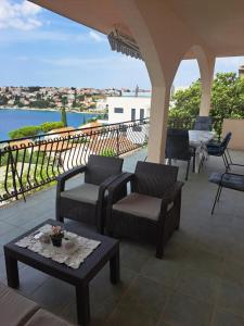 a patio with chairs and tables and a view of the water at Maiden Apartments in Trogir