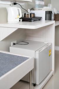 a kitchen with white shelves and a white appliance at We World Boutique Haatyai in Hat Yai