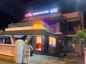 a house with a balcony on the front of it at Hotel Sunday - Townhouse Club Airport Trivandrum in Trivandrum