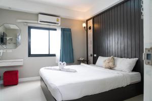 um quarto de hotel com duas camas e uma janela em We World Boutique Haatyai em Hat Yai