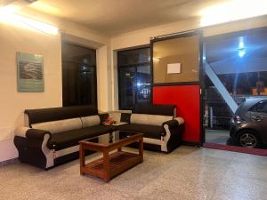 a living room with two couches and a table at Hotel Sunday - Townhouse Club Airport Trivandrum in Trivandrum