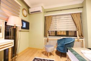 una camera da letto con una sedia blu e una finestra di WHITEMOON HOTEL SUİTES a Istanbul
