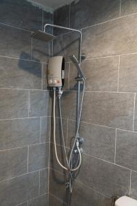 a shower in a bathroom with a shower head at We World Boutique Haatyai in Hat Yai