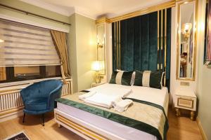 1 dormitorio con 1 cama y 1 silla azul en WHITEMOON HOTEL SUİTES en Estambul