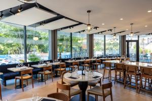 a restaurant with tables and chairs and large windows at Crowne Plaza - Marseille Le Dôme in Marseille
