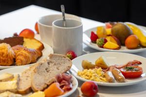 a table with plates of breakfast foods and a cup of coffee at Crowne Plaza - Marseille Le Dôme in Marseille