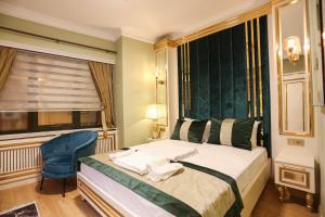 um quarto com uma cama, uma cadeira e uma janela em WHITEMOON HOTEL SUİTES em Istambul