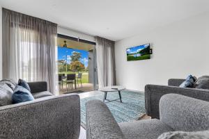 ein Wohnzimmer mit 2 Sofas und einem Tisch in der Unterkunft Comfort Suites Clubarham Golf Resort in Barham